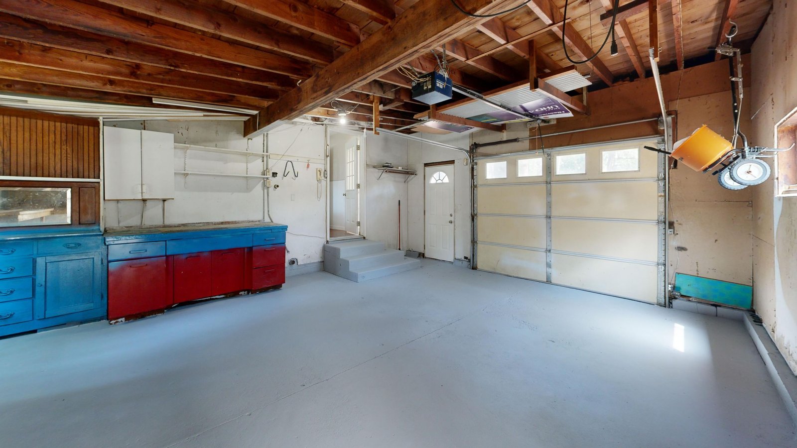 Empty garage with open space and colorful storage cabinets before epoxy flake finish