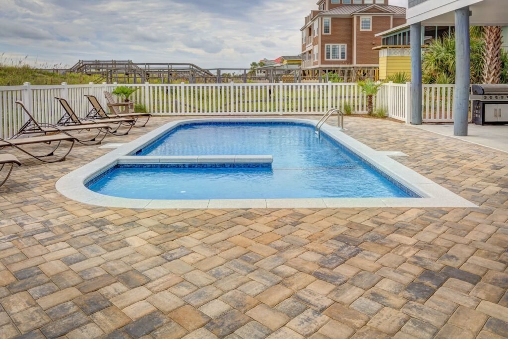 Poolside patio with epoxy coating, sun loungers, and villas in Charleston